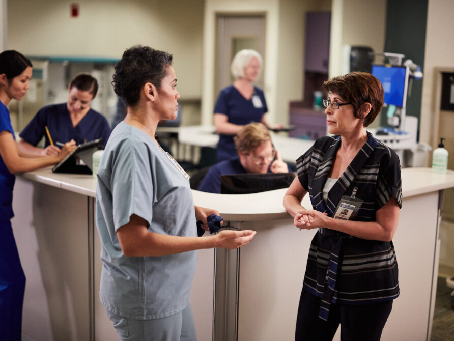 Two healthcare professionals engaging in conversation