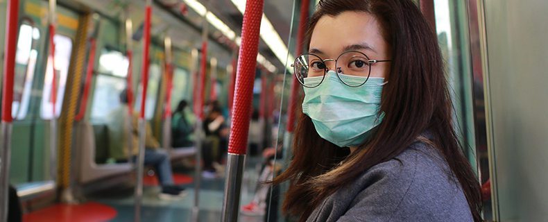 Woman wearing mask to protect from virus in public area.