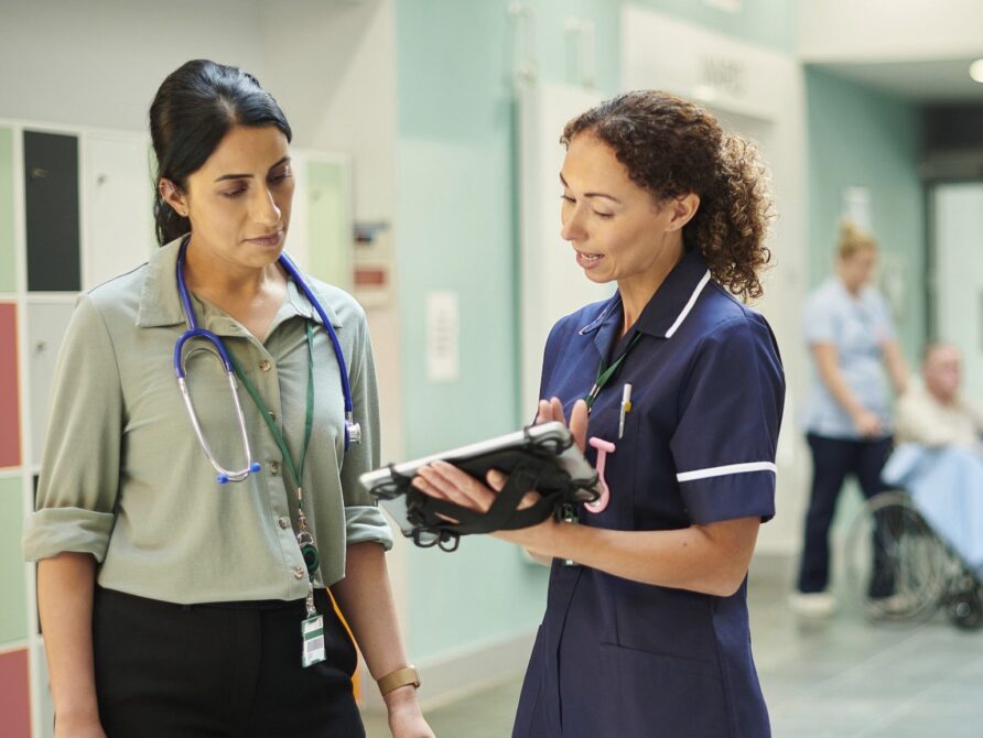 Two nurses looking at EHR on tablet